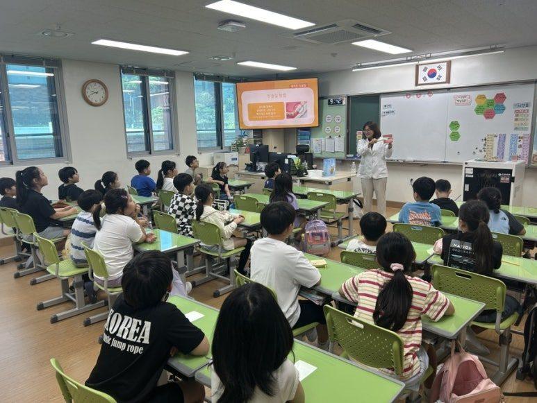 초등학교 교실에서 구강보건 교육을 듣는 학생들